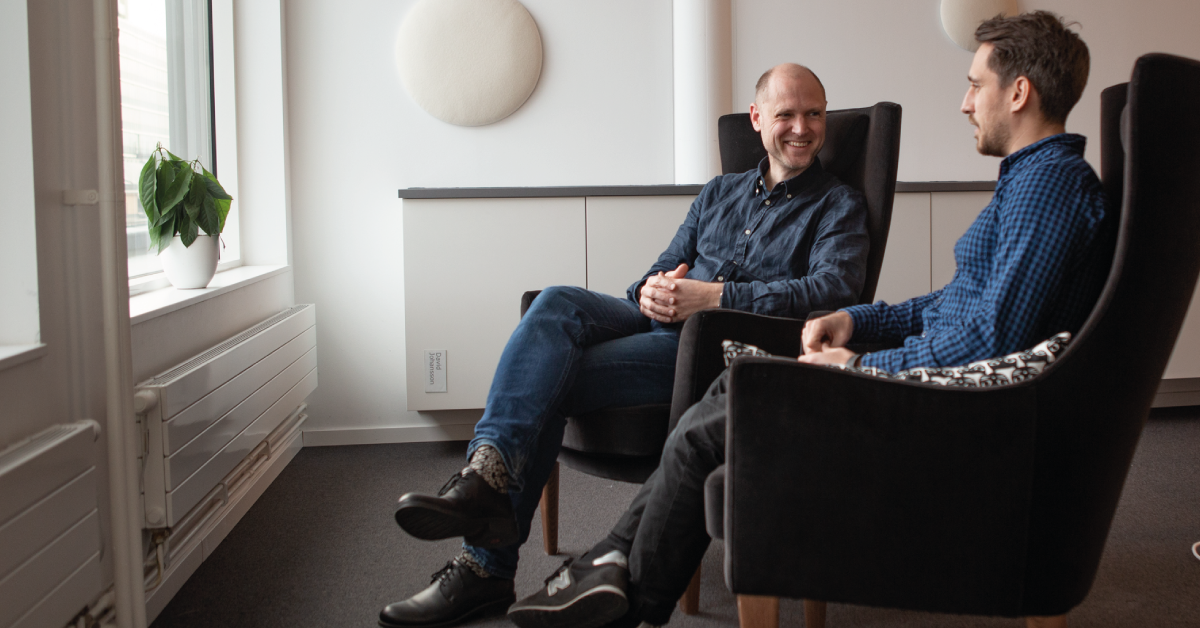 Dan och Alex sitter i vars en fåtölj och pratar