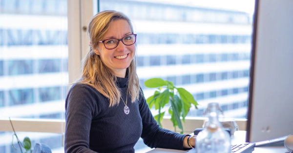 karin står vid ett skrivbord med dator